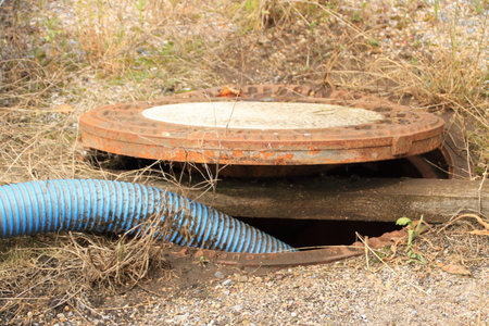 Hose is led into a sewage pipe and secured with a square timberの写真素材