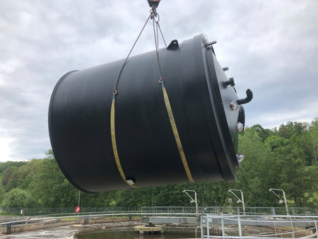 Liquid storage tank is lifted through the air onto a platformの写真素材