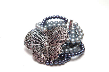 Elegant and modern bracelet with huge butterfly and glass pearls isolated on white backgroundの写真素材