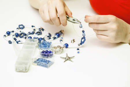 Woman making necklase from colorful plastic beadsの写真素材