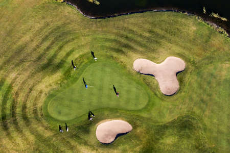Aerial view golfers enjoying a late season game on the golf courseの写真素材