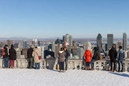 Montreal, March 8, 2015. Toruists and locals admiring the scenic view of the city skyline from the famed Mount-Royal on a sunny winter afternoon. Canada.のeditorial素材