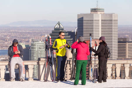 Montreal, March 8, 2015. Cross country skiers taking a break on the Mount-Royal belvedere to enjoy the skyline view on a sunny winter afternoon.のeditorial素材