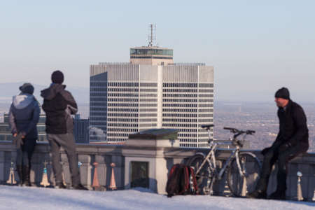 Montreal, March 8, 2015. A man and a woman admiring the panoramic skyline scene at the Mount Royal belvedere on a ssunny winter afternoon Montreal, Canadaのeditorial素材