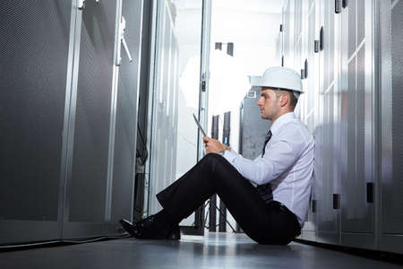 businessman hand using tablet computer in modern server roomの写真素材