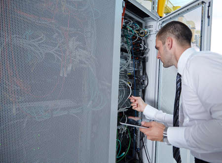 businessman hand using tablet computer in modern  server room