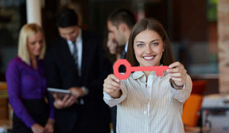 Image of pretty businesswoman looking at camera with keyの写真素材