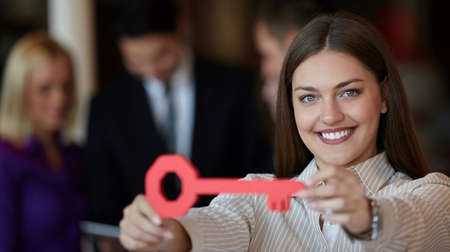 Image of pretty businesswoman looking at camera with keyの写真素材