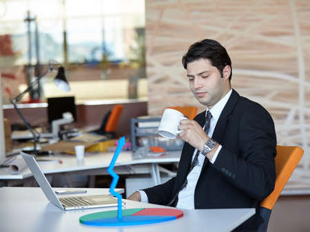 Elegant businessman analyzing data in officeの写真素材