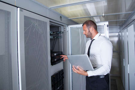it engeneer businessman with thin modern aluminium laptop in network server room