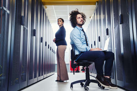 two young technicians working at a data center on server maintenance