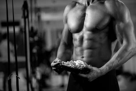 Eating food salad bodybuilding bodybuilder fitness gym body builder building muscles young man studioの写真素材