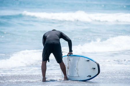 Surfing the waves of Indonesia beach. vacation concept