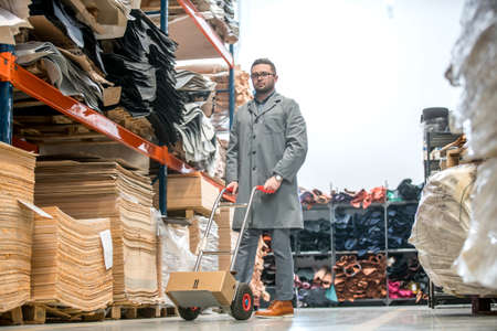 Working at leather warehouse at shoe factory used warehouse equipment. manager