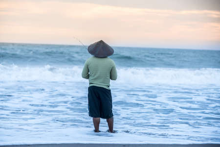 Man fishing in the evening at beachの写真素材