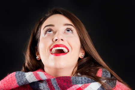 Pretty girl in warm winter clothes, isolated, on black backgroundの写真素材