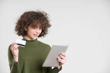 Hipster girl using blank credit card for online shopping. concept, on grey background
