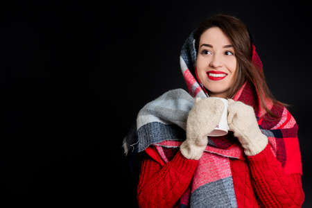 Pretty girl in warm winter clothes, isolated, on black backgroundの写真素材