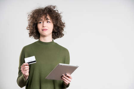 Hipster girl using blank credit card for online shopping. concept, on grey background
