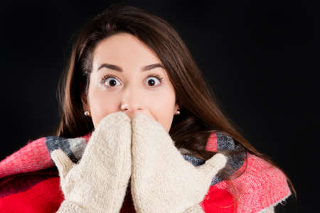 Pretty girl in warm winter clothes, isolated, on black background