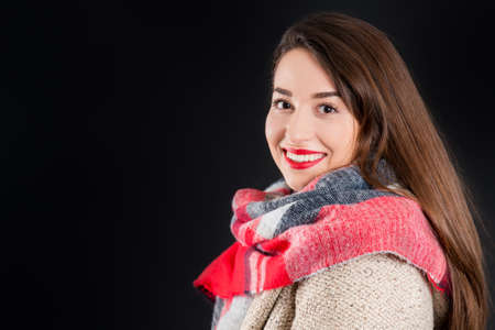 Pretty girl in warm winter clothes, isolated, on black backgroundの写真素材