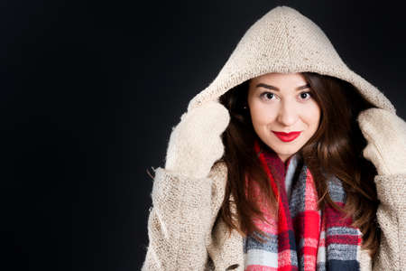 Pretty girl in warm winter clothes, isolated, on black backgroundの写真素材