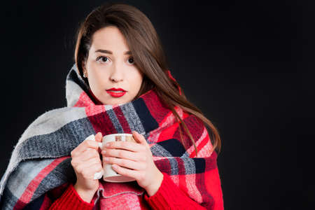 Pretty girl in warm winter clothes, isolated, on black backgroundの写真素材