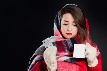 Pretty girl in warm winter clothes, isolated, on black backgroundの写真素材
