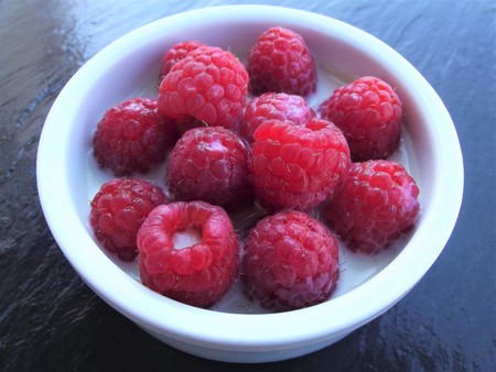 Bowl of raspberries with milkの写真素材
