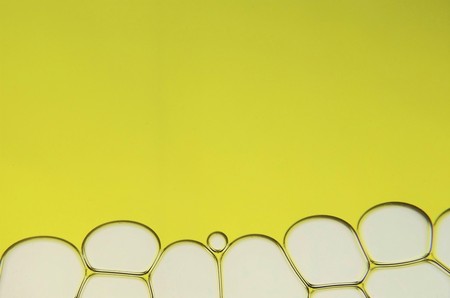 Bubbles on a yellow background with space for textの写真素材