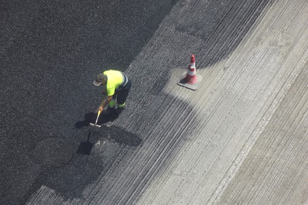 A worker extends asphalt on a streetの写真素材