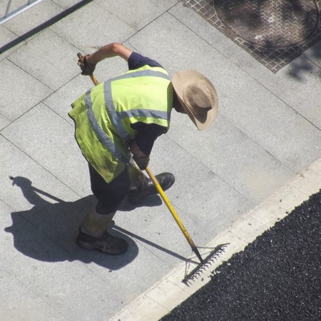 A worker extends asphalt on a streetの写真素材