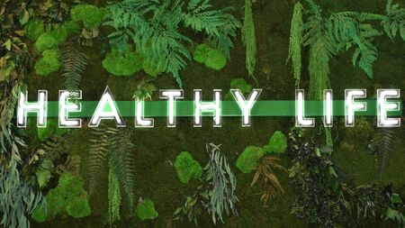 Luminous sign Healthy life composed of letters placed on a bar with a vegetal background