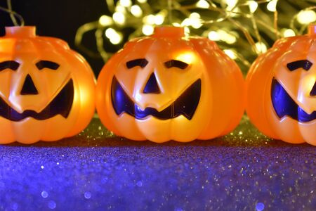 Several halloween smiling pumpkins illuminated with magic light