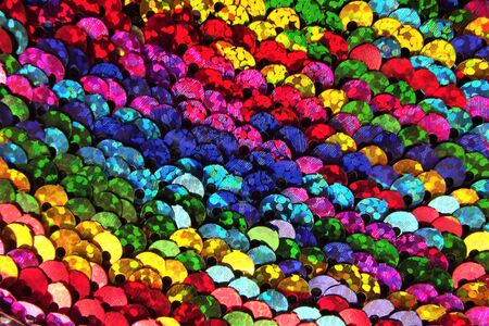 Detail of multicolored sequins sewn on a fabric. Sequins background.