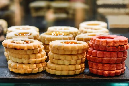Close-up of a tray of layered flower-shaped butter cookies of different flavors filled with jam. Unhealthy eating conceptの写真素材