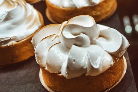 Close-up of a circular butter sponge cake covered with toasted and creamy meringue. Unhealthy eating...