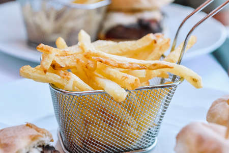 Macro view of potato chips in a basket on a table. Fast food concept