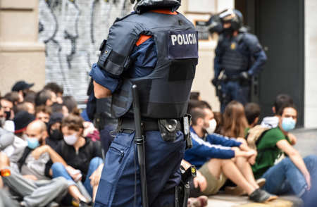 Barcelona / Spain, 2020-09-22 Neighborhood protest against the eviction for non-payment of rent. The police watch a group of protesters sitting in front of the door of the house which are going to evict.のeditorial素材