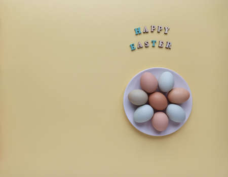 Colorful Easter eggs on a plate. Easter holiday concept, flat layout, top view.
