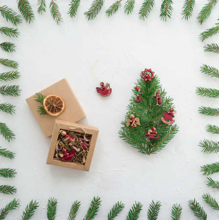New Years gift and festive Christmas tree on a white background with green spruce branchesの写真素材
