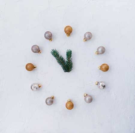 A fern branch with blue balls instead of a Christmas A concert celebrating the new year. A clock made of Christmas tree toys, shiny balls. The hands of the clock made of green spruce branches.の写真素材