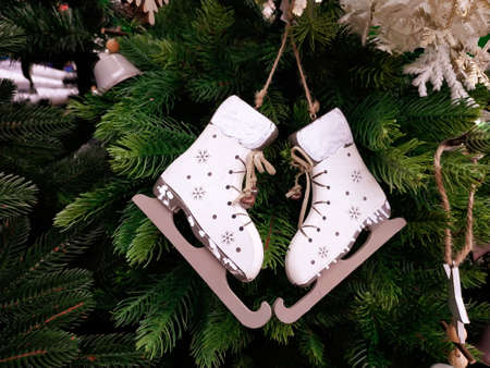 White wooden skates on a green spruce branch. Home Christmas decor.の写真素材