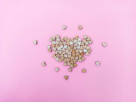 A big heart made of many small wooden hearts on a pink-purple background. Cute Valentines Day card