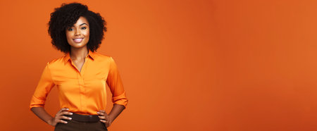 Beautiful african american woman with afro hairstyle posing on orange background. Business Woman Concept.の素材