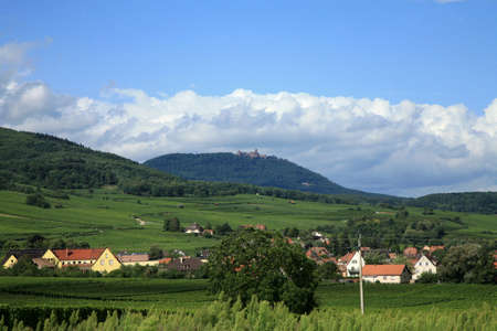 Haut Koenigsbourg castle on peak of Vosges. Vineyards and small village in the valley. Alsace, France.の写真素材