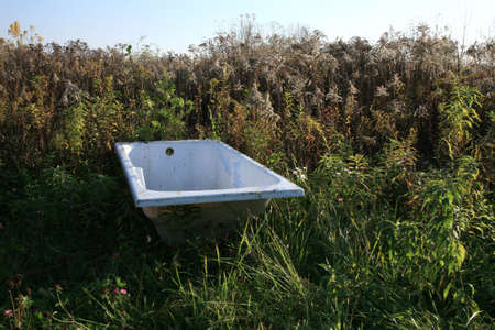 Bathtub thrown away on the meadow - of civilization wastes - threat to the natural environment. Expansion of the man. Devastation of the natural environment.の写真素材