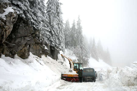 Snowplow in action on rural snow covered road. Winter in Balkans Mountain - Kosovo