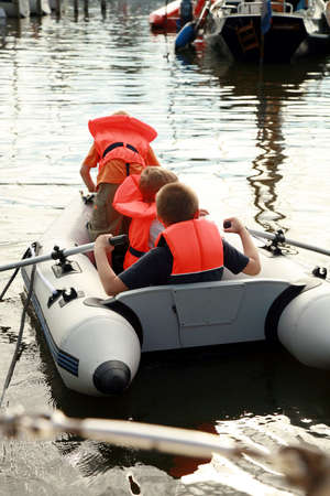 Group of children, boys is sailing out on the pontoon. Play on water during summer holidays.の写真素材