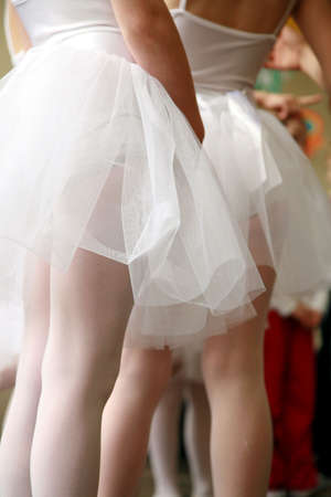 Little ballerinas dancing on a school show. Schoolgirls dressed in white dresses ( tutu ) の写真素材